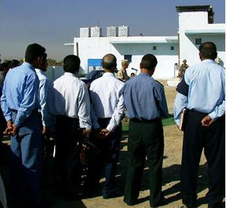 Iraqi Police watch the dedication ceremony of their new Highway Police Station
